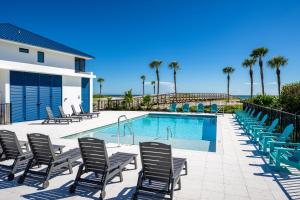 a pool with chaise lounge chairs and a swimming pool at Shalimar Beach Resort in Sanibel