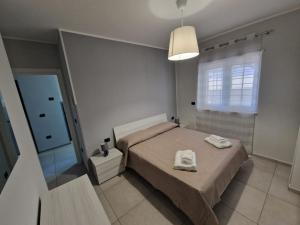 a bedroom with a bed with two towels on it at Casa Alba Napoli in Naples