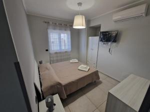 een kleine slaapkamer met een bed in een kamer bij Casa Alba Napoli in Napels +5 foto's