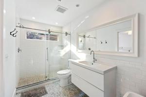 Un baño blanco con inodoro y lavabo. en LV19: 19 Lake Village, en Isle of Palms 42 fotos más