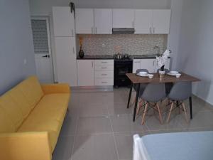 a living room with a yellow couch and a table at T0 Brisa Tropical in Sal Rei