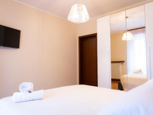 a bedroom with a white bed and a mirror at Civico 5 in Piacenza