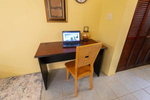 a laptop computer sitting on a desk with a chair at Coconut Haven in East End Village