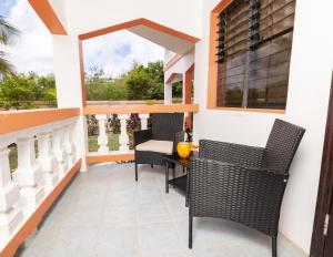a patio with chairs and a table on a balcony at Coconut Haven in East End Village