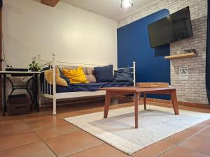 a living room with a blue couch and a table at Gîte familial 10 pers jardin et piscine in Saint-Amour
