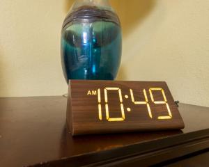a clock sitting on top of a table with a vase at Coconut Haven in East End Village