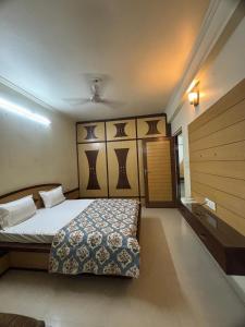 ein Schlafzimmer mit einem Bett mit gemusterter Tagesdecke in der Unterkunft The Modern Monastery in Jaipur