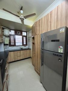 eine Küche mit Edelstahlkühlschrank und Holzschränken in der Unterkunft The Modern Monastery in Jaipur