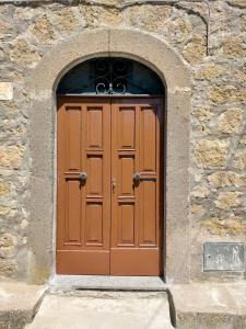 a large wooden door in a stone building at Le coste sul lago in Montefiascone