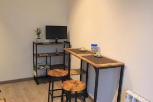 a room with a bar with stools and a television at Casa Kokoro in Staranzano