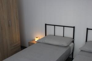 a bedroom with two beds and a night stand with a lamp at Casa Kokoro in Staranzano