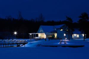 un edificio en la nieve por la noche en AaltoSahan huvila, en Orivesi
