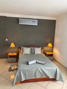 a bedroom with a bed with two pillows on it at Charming Apartment with Pool View Near the Beach in Flic-en-Flac