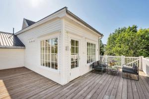 a white house with a deck with two chairs at Arctic hilltop lodge - Room 1 in Guleng +6 photos