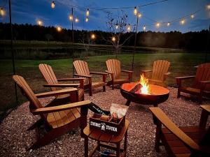 eine Gruppe von Stühlen und eine Feuerstelle in einem Hof in der Unterkunft Whispering Pines Retreat, Secluded Cabin with Hot Tub & Pond in Jacksonville