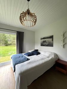 a bedroom with a bed and a chandelier at Villa Ketola in Ranua