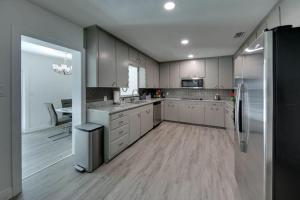 a kitchen with white cabinets and stainless steel appliances at Relaxing Pool Side - Near Fairgrounds in Palmetto