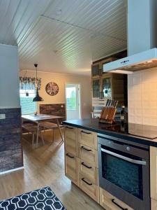 a kitchen with a stove top oven next to a table at Villa Ketola in Ranua +27 photos