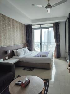 a hotel room with a bed and a large window at Tarragon Family Suite Apartment in Kuala Lumpur