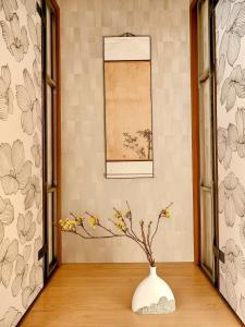 um vaso branco sobre uma mesa com flores em Luna Luxury 4BR Family Villa with Parking - 2 mins from Osaka-ko Station, near EXPO, USJ, Kaiyukan em Osaka