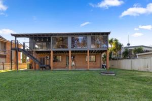 a house with a staircase in a yard at San Remo Charm with Waterfront Views and Sunroom in Blue Haven