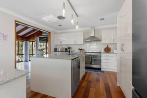 a kitchen with white cabinets and stainless steel appliances at San Remo Charm with Waterfront Views and Sunroom in Blue Haven