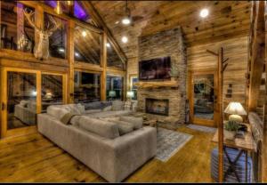a living room with a couch and a stone fireplace at Mountain views, Fire Pit, Game Room in Hurst
