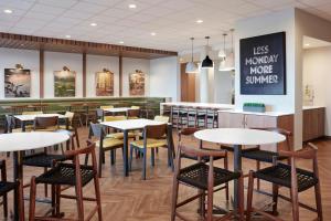 a restaurant with tables and chairs and a bar at Fairfield by Marriott Inn & Suites Detroit Sterling Heights in Sterling Heights