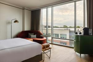 una habitación de hotel con una cama y una ventana grande en The Tess, Autograph Collection, en Atlanta