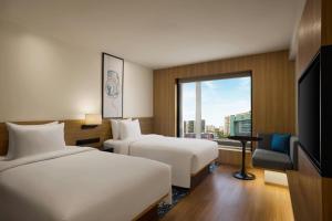 a hotel room with two beds and a window at Fairfield by Marriott Mumbai Andheri West in Mumbai +40 photos