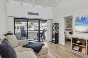 a living room with a couch and a tv and a table at 1555 Tarpon Center #B212 in Venice Beach