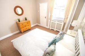 um quarto com uma cama branca e um espelho em Sillwood Balcony Apartment - Central - by Brighton Holiday Lets em Brighton & Hove