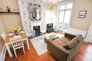 a living room with a couch and a table at Sillwood Balcony Apartment - Central - by Brighton Holiday Lets in Brighton & Hove