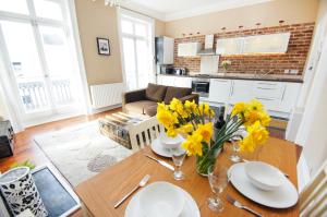 uma sala de estar com uma mesa com flores amarelas em Sillwood Balcony Apartment - Central - by Brighton Holiday Lets em Brighton & Hove