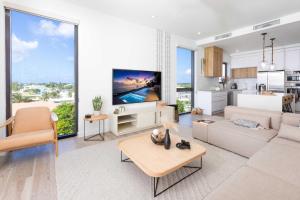 a living room with a couch and a tv at SeaDreams 8 - Luxury Condo with Shared Pool, Hot Tub, Rooftop Lounge in West Bay +13 photos