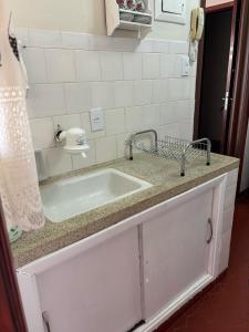 a kitchen counter with a sink in a bathroom at Apto Central com garagem in Serra Negra