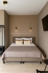 a bedroom with a large bed and a flat screen tv at Manor Suite Amsterdam in Amsterdam