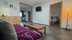 a living room with a couch and a coffee table at Appartment Herzblick in Sankt Georgen im Gailtal