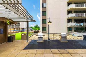 un patio avec trois bancs et un bâtiment dans l'établissement Spacious Apt W Great Spaces & Facilities, à Addison Heights