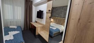 a hotel room with a bed and a television at Sremski Kutak in Stara Pazova