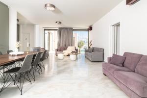 a living room with a couch and a table and chairs at NOPI HOLIDAYS Zante Exclusive Villa in Zakynthos Town