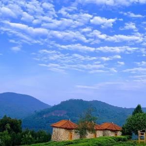 two buildings on a hill with mountains in the background at Kitabi EcoCenter in Gabegi +38 photos