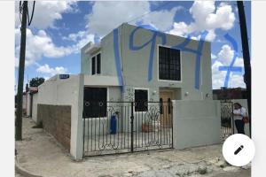 a white house with blue graffiti on it at Depa Pakabtun Descansa sin pagar de mas 2 hab wifi y AC in Mérida