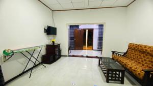 a living room with a couch and a television at "The Secret Hill" in Matara