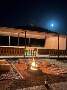 a fire pit in front of a building at night at Wadi Rum Grand in Wadi Rum