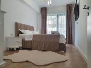 ein Schlafzimmer mit zwei Betten und einem Teppich in der Unterkunft White Silk - Premium Apartment with free underground parking in Iaşi