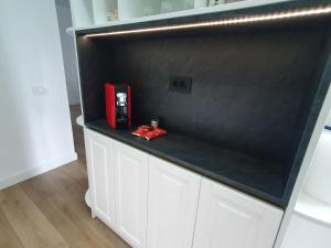 eine Theke mit einem roten Gerät darauf in der Unterkunft White Silk - Premium Apartment with free underground parking in Iaşi