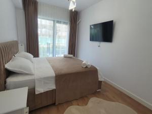 ein Schlafzimmer mit einem Bett und einem TV an der Wand in der Unterkunft White Silk - Premium Apartment with free underground parking in Iaşi