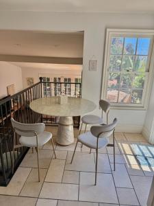une table et des chaises dans une pièce avec une fenêtre dans l'établissement Entire villa on Sunset Strip, à Los Angeles