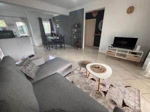 a living room with a couch and a table at Charming Apartment with Pool View Near the Beach in Flic-en-Flac